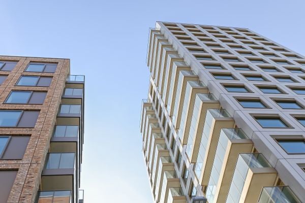 A picture of tall, towerblock social housing accommodation facing the sun.